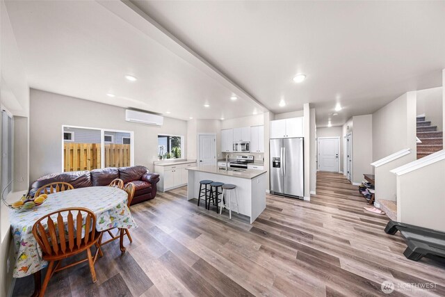 2912 Sandwood Ln, Blaine, WA 98230 - living area with a wall mounted AC, light wood-type flooring, recessed lighting, and stairway