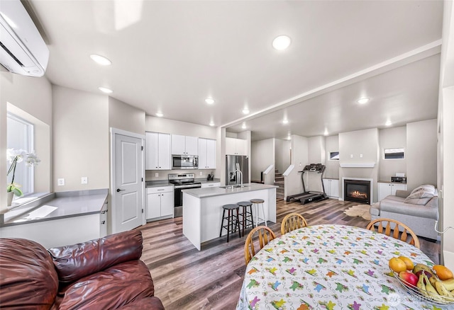 2912 Sandwood Ln, Blaine, WA 98230 - living area with an AC wall unit, wood finished floors, recessed lighting, and a glass covered fireplace