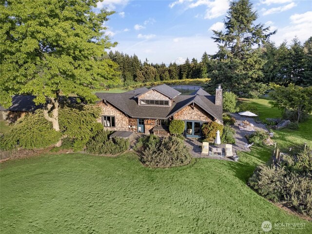 26742 94th Ave SW, Vashon, WA 98070 - view of front facade with a front lawn, a patio area, a chimney, and stone siding