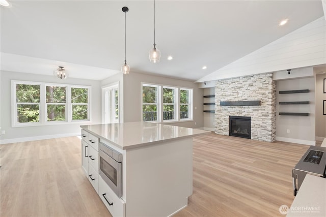 19 Inglewood Pl, Bellingham, WA 98229 - kitchen featuring stainless steel microwave, open floor plan, light wood-style floors, recessed lighting, and high vaulted ceiling