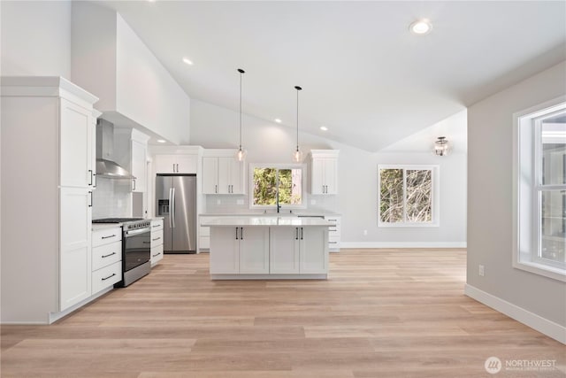 19 Inglewood Pl, Bellingham, WA 98229 - kitchen featuring appliances with stainless steel finishes, wall chimney range hood, white cabinets, vaulted ceiling, and light countertops
