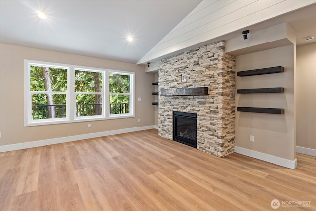 19 Inglewood Pl, Bellingham, WA 98229 - unfurnished living room featuring lofted ceiling, baseboards, light wood-type flooring, and a stone fireplace
