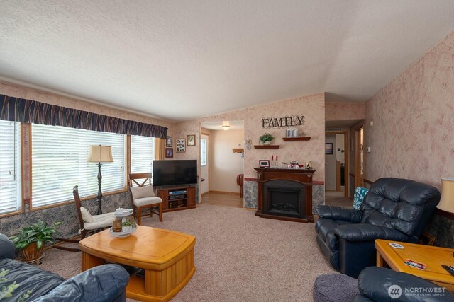 307 Hilltop Cir, Ephrata, WA 98823 - living area featuring wallpapered walls, vaulted ceiling, carpet floors, and a fireplace