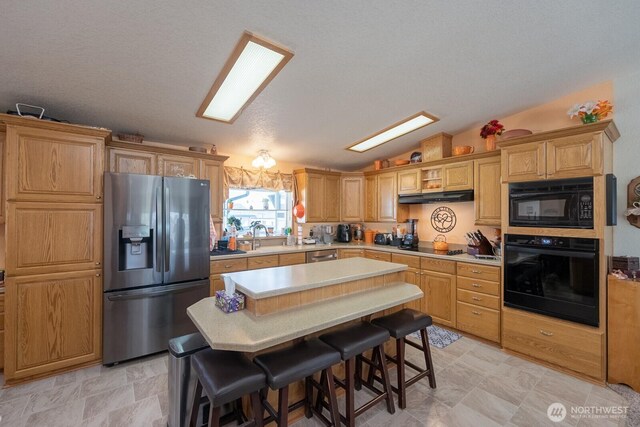307 Hilltop Cir, Ephrata, WA 98823 - kitchen with black appliances, light countertops, vaulted ceiling, under cabinet range hood, and a center island