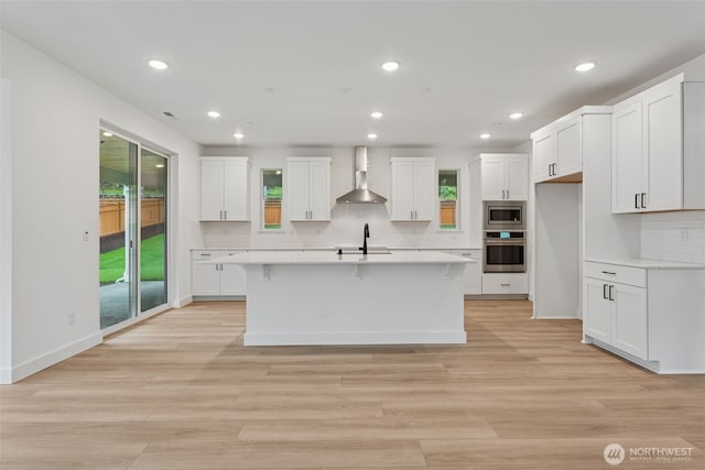 15706 210th Ave E Unit 312, Bonney Lake, WA 98391 - kitchen featuring stainless steel appliances, wall chimney exhaust hood, a sink, healthy amount of natural light, and recessed lighting