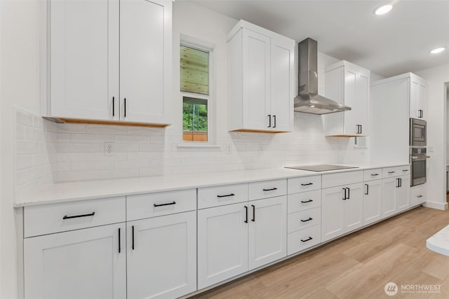 15706 210th Ave E Unit 312, Bonney Lake, WA 98391 - kitchen with wall chimney exhaust hood, appliances with stainless steel finishes, light wood-style flooring, white cabinets, and recessed lighting