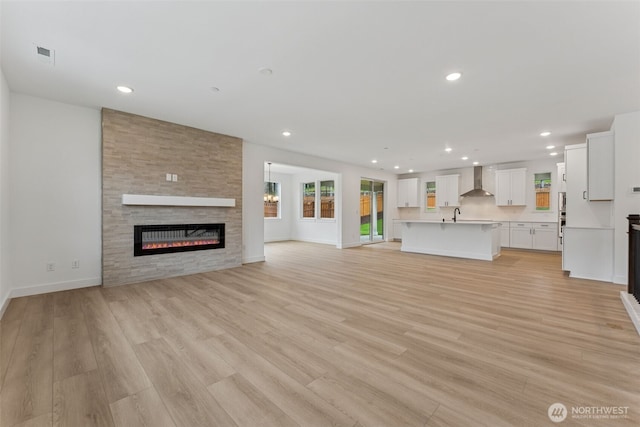 15706 210th Ave E Unit 312, Bonney Lake, WA 98391 - unfurnished living room featuring a large fireplace, light wood-style floors, recessed lighting, and baseboards