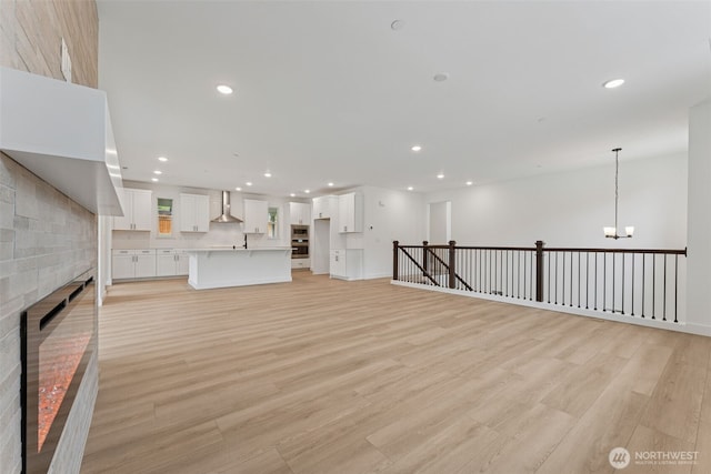 15706 210th Ave E Unit 312, Bonney Lake, WA 98391 - unfurnished living room with recessed lighting, light wood finished floors, a chandelier, and a brick fireplace