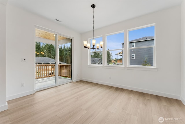 15706 210th Ave E Unit 312, Bonney Lake, WA 98391 - unfurnished dining area featuring a chandelier, baseboards, and light wood-style floors
