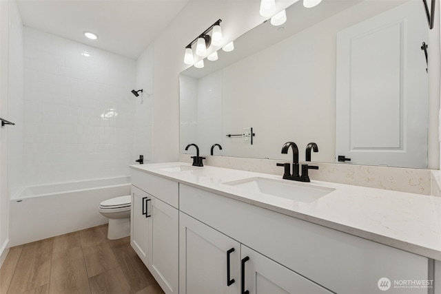 15706 210th Ave E Unit 312, Bonney Lake, WA 98391 - bathroom featuring wood finished floors, double vanity, toilet, and shower / washtub combination