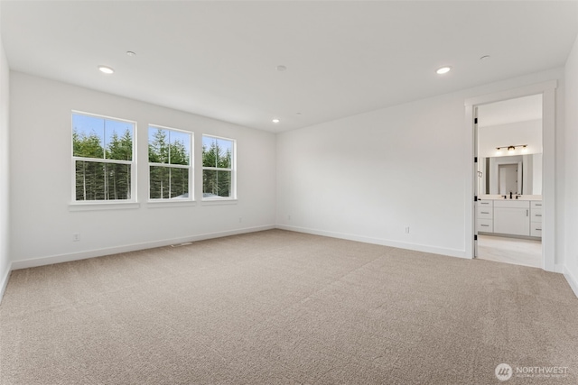 15706 210th Ave E Unit 312, Bonney Lake, WA 98391 - empty room featuring light colored carpet, baseboards, recessed lighting, and a sink