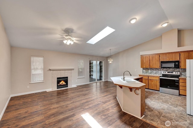 8115 109th St E Unit 8117, Puyallup, WA 98373 - kitchen featuring electric stove, black microwave, a sink, brown cabinetry, and light countertops