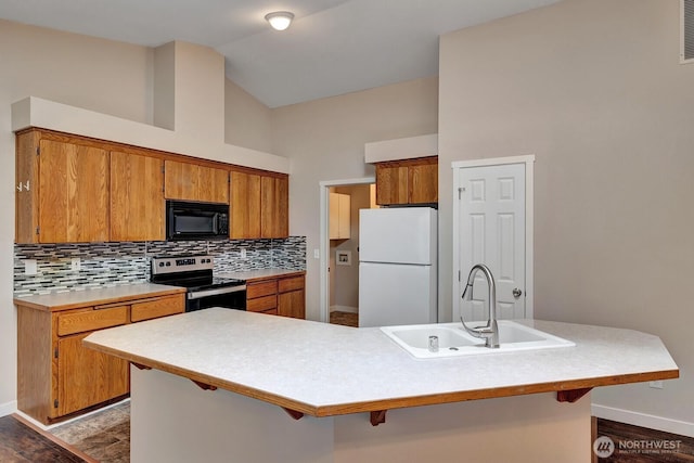 8115 109th St E Unit 8117, Puyallup, WA 98373 - kitchen featuring stainless steel range with electric stovetop, freestanding refrigerator, black microwave, a sink, and baseboards