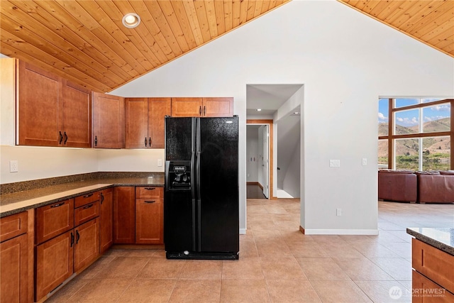 340 W Beach Dr, Orondo, WA 98843 - kitchen with black fridge, wooden ceiling, high vaulted ceiling, brown cabinetry, and light tile patterned floors