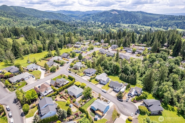 1426 Pries Ct, Kelso, WA 98626 - aerial perspective of suburban area featuring a heavily wooded area and a mountainous background