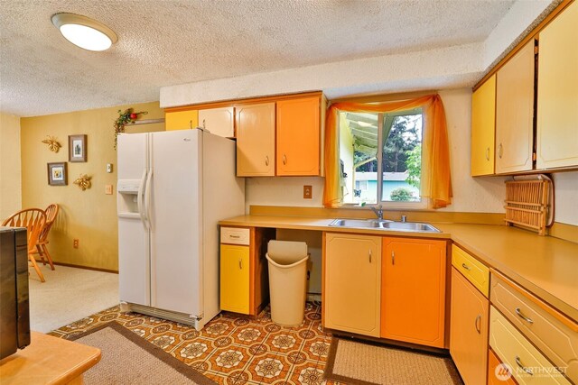 247 Bass Ave NE, Ocean Shores, WA 98569 - kitchen featuring white refrigerator with ice dispenser, a sink, a textured ceiling, light countertops, and light floors