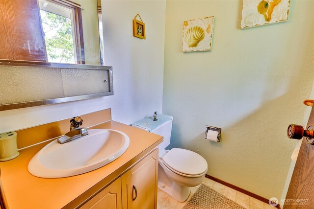 247 Bass Ave NE, Ocean Shores, WA 98569 - bathroom with toilet, vanity, and baseboards