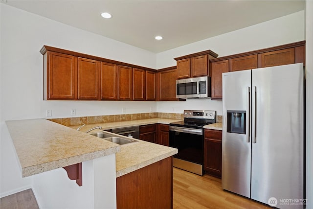 4825 E Q St Unit 2922, Tacoma, WA 98404 - kitchen with stainless steel appliances, a sink, a peninsula, light countertops, and light wood-style floors