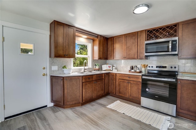 1108 116th St S, Tacoma, WA 98444 - kitchen featuring stainless steel appliances, light countertops, light wood-style flooring, and tasteful backsplash
