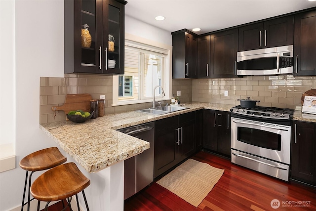 3122 Franklin Ave E Unit A, Seattle, WA 98102 - kitchen with stainless steel appliances, a sink, dark wood finished floors, glass insert cabinets, and light stone counters