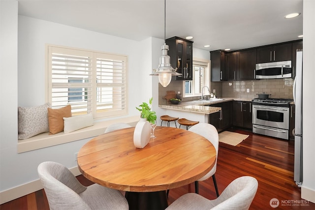 3122 Franklin Ave E Unit A, Seattle, WA 98102 - kitchen with appliances with stainless steel finishes, decorative backsplash, dark wood finished floors, a sink, and recessed lighting