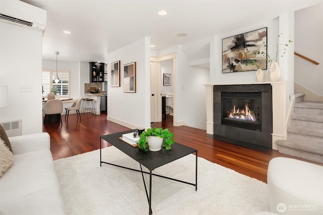 3122 Franklin Ave E Unit A, Seattle, WA 98102 - living area featuring a wall mounted air conditioner, wood finished floors, stairs, a fireplace, and recessed lighting