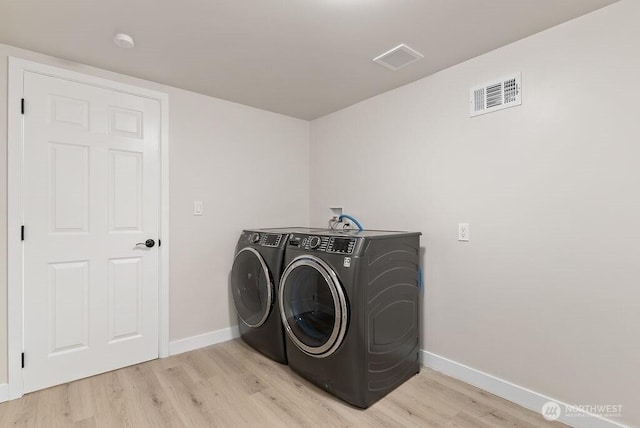 11433 SE 244th St, Kent, WA 98030 - laundry area with washer and dryer, light wood-style flooring, and baseboards