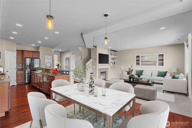 317 Phoenix Ave SW, Orting, WA 98360 - dining area with dark wood finished floors, a tile fireplace, and recessed lighting