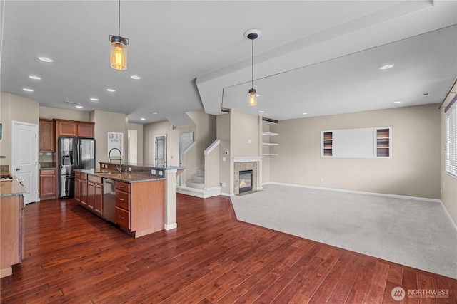 317 Phoenix Ave SW, Orting, WA 98360 - kitchen with refrigerator with ice dispenser, dark wood finished floors, dark stone countertops, decorative light fixtures, and recessed lighting
