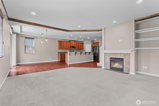 317 Phoenix Ave SW, Orting, WA 98360 - unfurnished living room featuring dark carpet, baseboards, a tile fireplace, recessed lighting, and dark wood-style floors