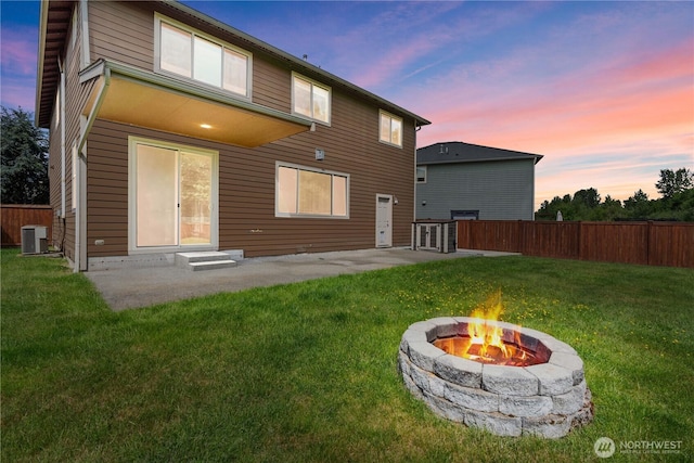 317 Phoenix Ave SW, Orting, WA 98360 - back of house at dusk featuring an outdoor fire pit, cooling unit, a patio, and entry steps