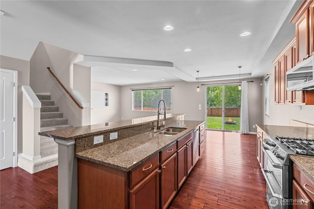 317 Phoenix Ave SW, Orting, WA 98360 - kitchen with a sink, stainless steel appliances, dark wood-style flooring, a kitchen island with sink, and dark stone counters