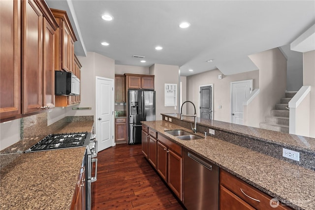 317 Phoenix Ave SW, Orting, WA 98360 - kitchen with appliances with stainless steel finishes, a sink, dark wood-type flooring, dark stone countertops, and recessed lighting