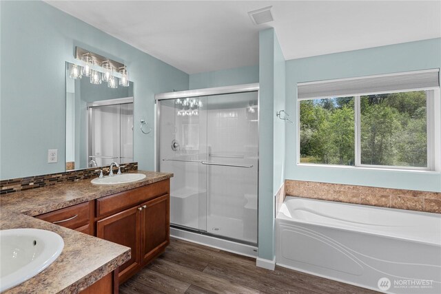 317 Phoenix Ave SW, Orting, WA 98360 - full bathroom featuring vanity, a shower stall, wood finished floors, a bath, and plenty of natural light