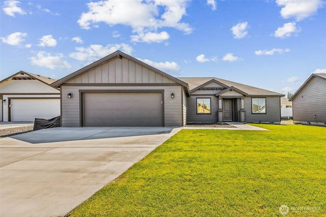 217 N Sandy Loop, Moses Lake, WA 98837 - view of front of property with a garage, concrete driveway, a front lawn, and board and batten siding