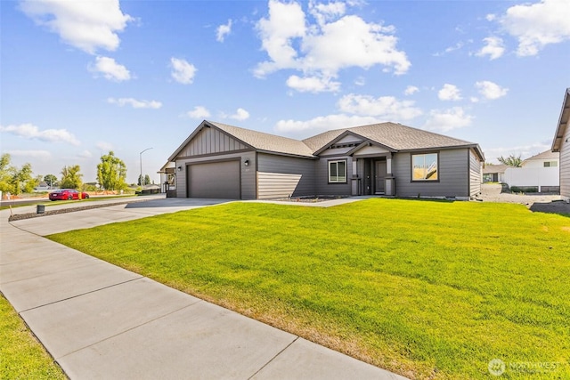 217 N Sandy Loop, Moses Lake, WA 98837 - view of front facade featuring board and batten siding, driveway, a front lawn, and an attached garage