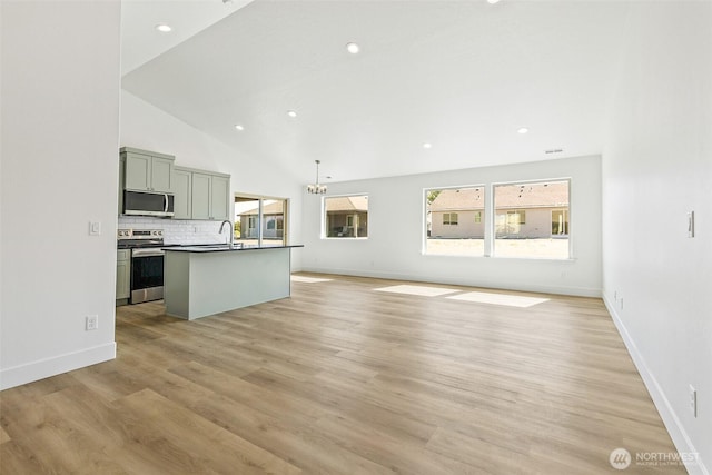 217 N Sandy Loop, Moses Lake, WA 98837 - unfurnished living room featuring light wood-style floors, vaulted ceiling, recessed lighting, and a chandelier