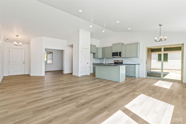 217 N Sandy Loop, Moses Lake, WA 98837 - kitchen with a chandelier, stainless steel microwave, dark countertops, open floor plan, and high vaulted ceiling