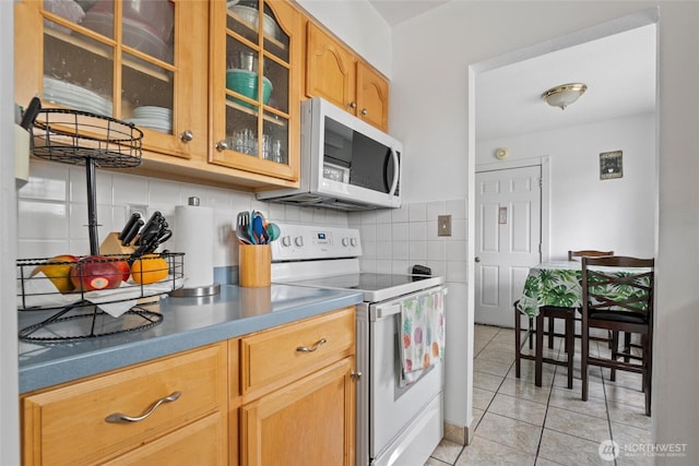 1223 Arnold Dr, Moses Lake, WA 98837 - kitchen with white appliances, light tile patterned flooring, glass insert cabinets, and backsplash