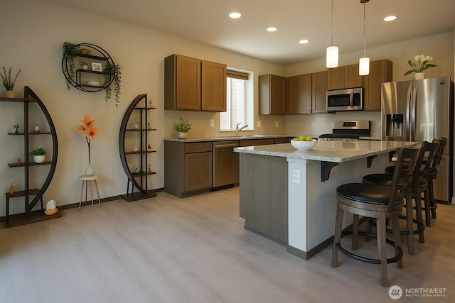 3361 Inverness St, Mount Vernon, WA 98273 - kitchen with appliances with stainless steel finishes, recessed lighting, a breakfast bar, a kitchen island, and light wood-style flooring