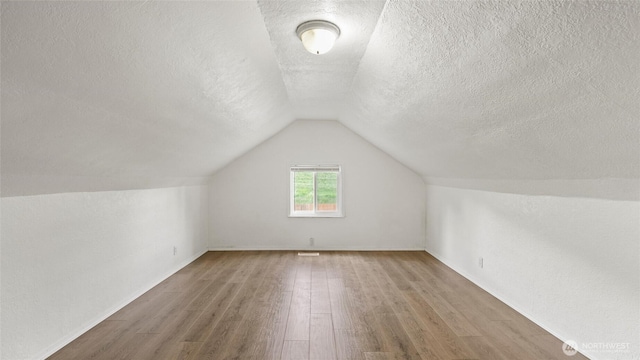 427 E Dayton Ave, Dayton, WA 99328 - bonus room featuring wood finished floors, a textured ceiling, lofted ceiling, and baseboards