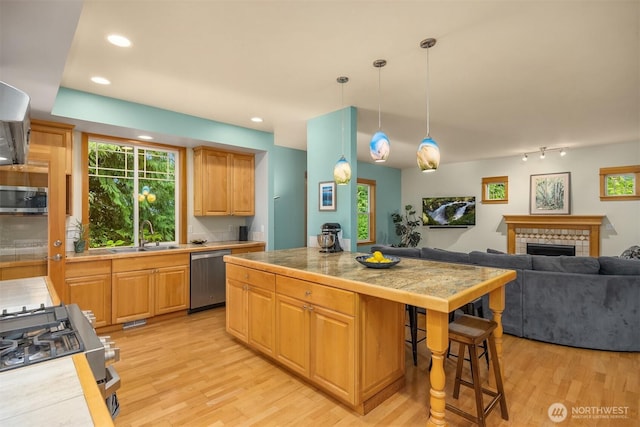6570 Cedar Glade Ln, Bainbridge Island, WA 98110 - kitchen featuring stainless steel appliances, a sink, light wood-style floors, a breakfast bar, and recessed lighting