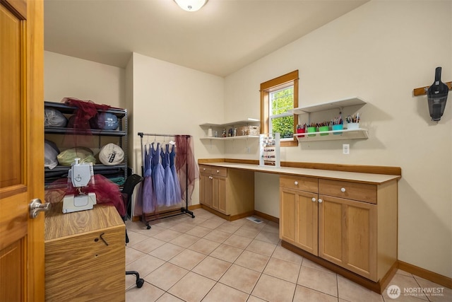 6570 Cedar Glade Ln, Bainbridge Island, WA 98110 - laundry area with light tile patterned floors, a desk, and baseboards