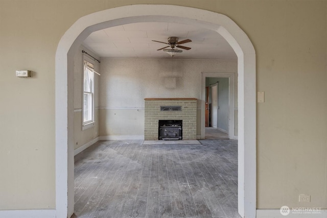 1908 W State Route 4 Unit 1, Skamokawa, WA 98647 - unfurnished living room with a ceiling fan, wood finished floors, arched walkways, and baseboards