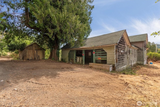 1908 W State Route 4 Unit 1, Skamokawa, WA 98647 - view of side of home with an outbuilding and a shingled roof