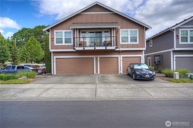 6018 Illinois Ln SE Unit B, Lacey, WA 98513 - view of front facade featuring an attached garage, board and batten siding, concrete driveway, central air condition unit, and a balcony