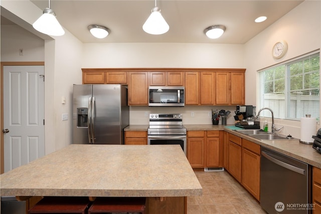 6018 Illinois Ln SE Unit B, Lacey, WA 98513 - kitchen with appliances with stainless steel finishes, a sink, hanging light fixtures, and brown cabinets