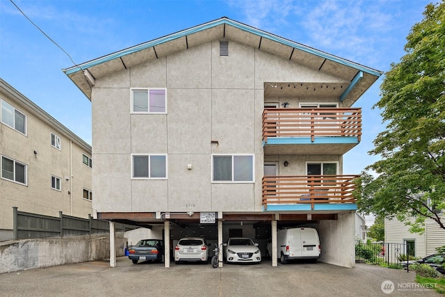 6710 24th Ave NW, Seattle, WA 98117 - back of house with stucco siding, a balcony, and covered parking