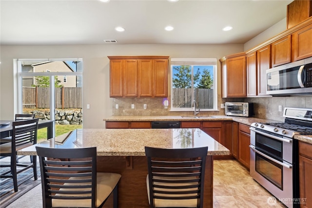9831 198th St E, Graham, WA 98338 - kitchen with appliances with stainless steel finishes, plenty of natural light, recessed lighting, tasteful backsplash, and a center island