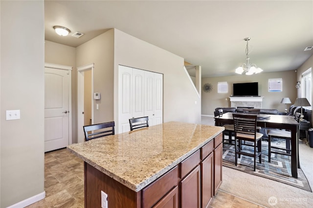 9831 198th St E, Graham, WA 98338 - kitchen with decorative light fixtures, light stone countertops, a kitchen island, a chandelier, and open floor plan